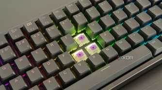 Close-up of the Keychron K2 HE with three keycaps removed, showing the switches underneath