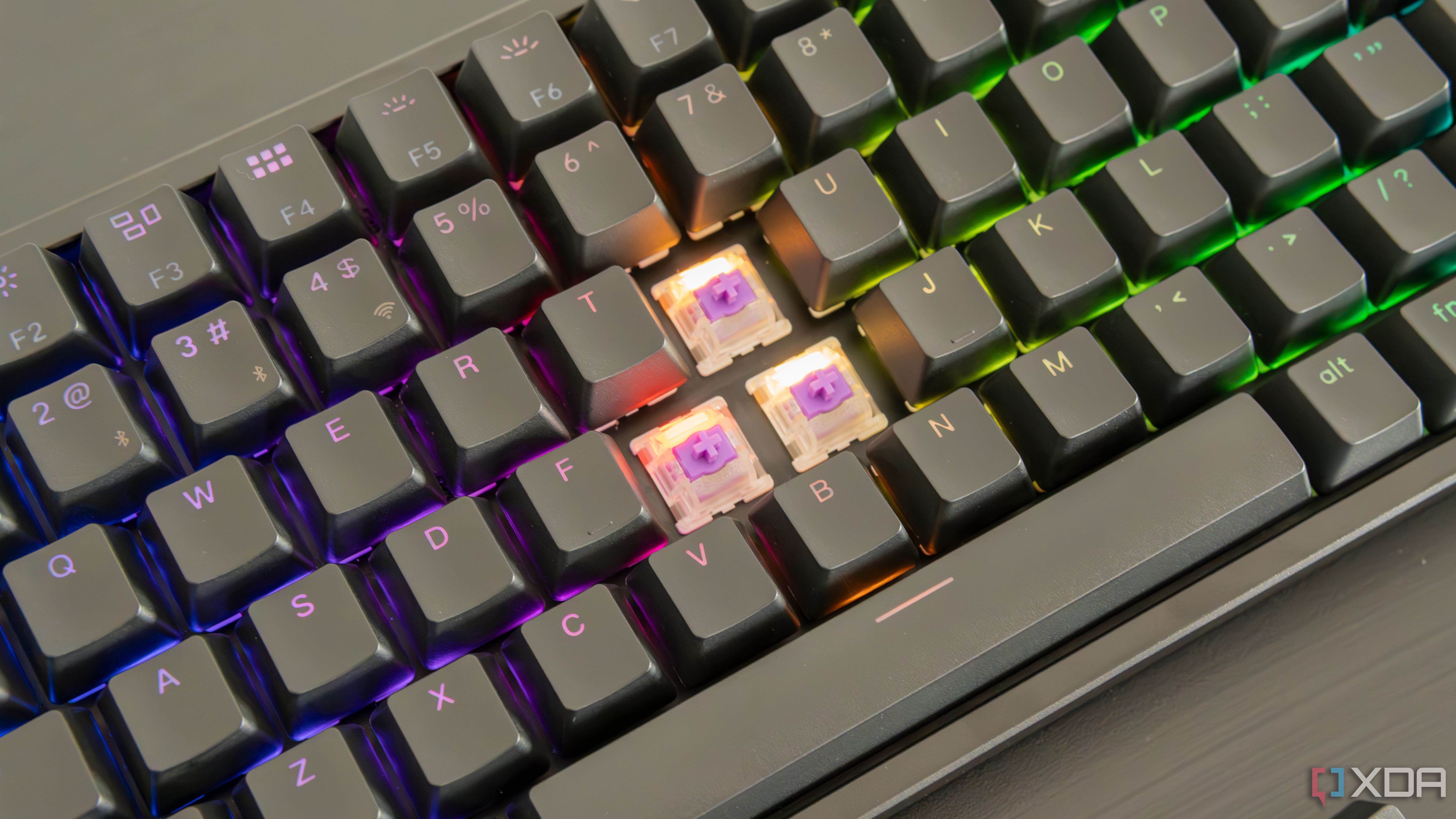 Close-up of the Keychron K2 HE with three keycaps removed, showing the switches underneath