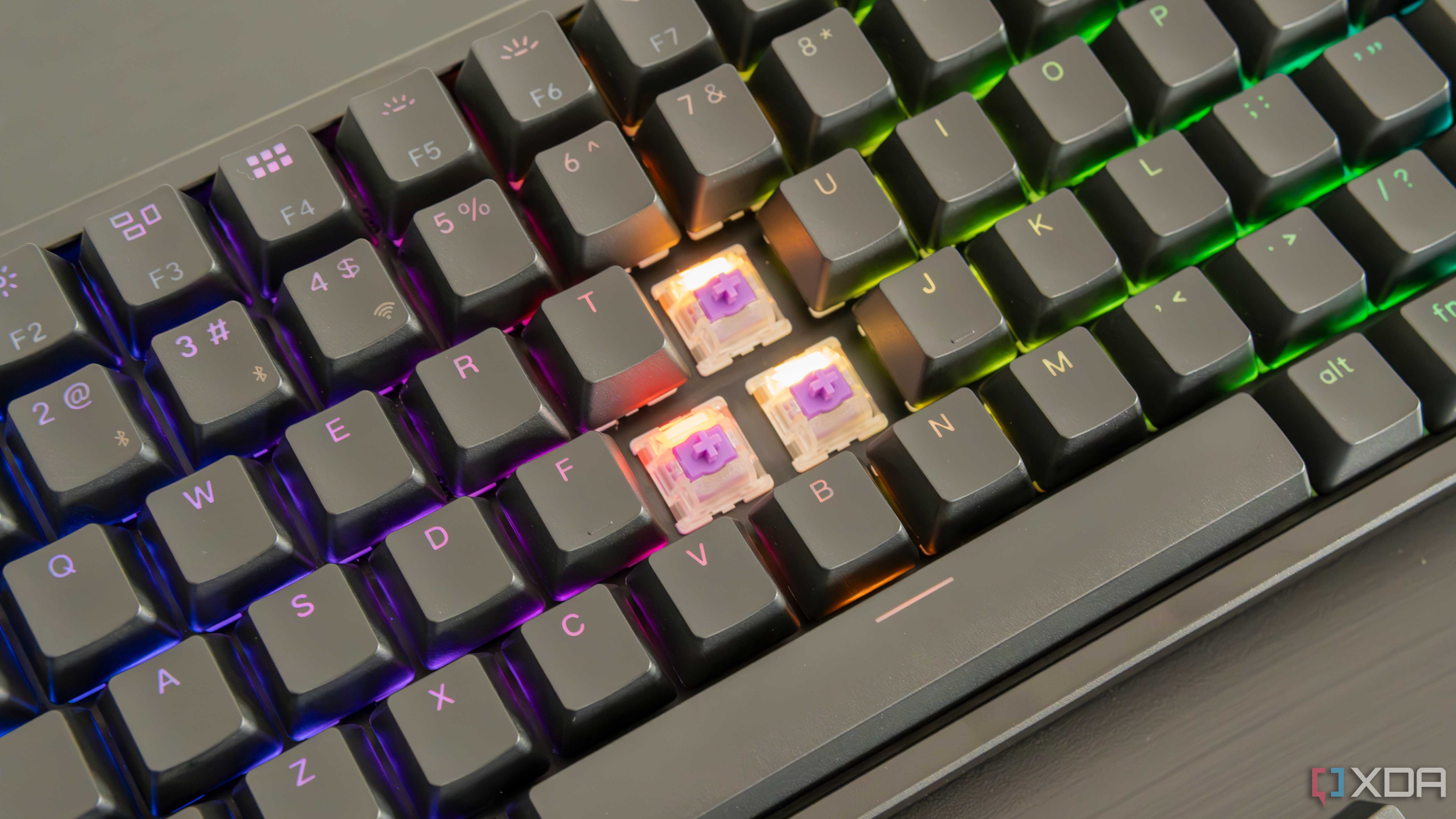Close-up of the Keychron K2 HE with three keycaps removed, showing the switches underneath