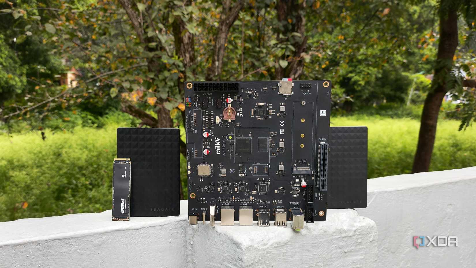 A Milk-V Jupiter placed near two external HDDs and a Crucial NVMe SSD 