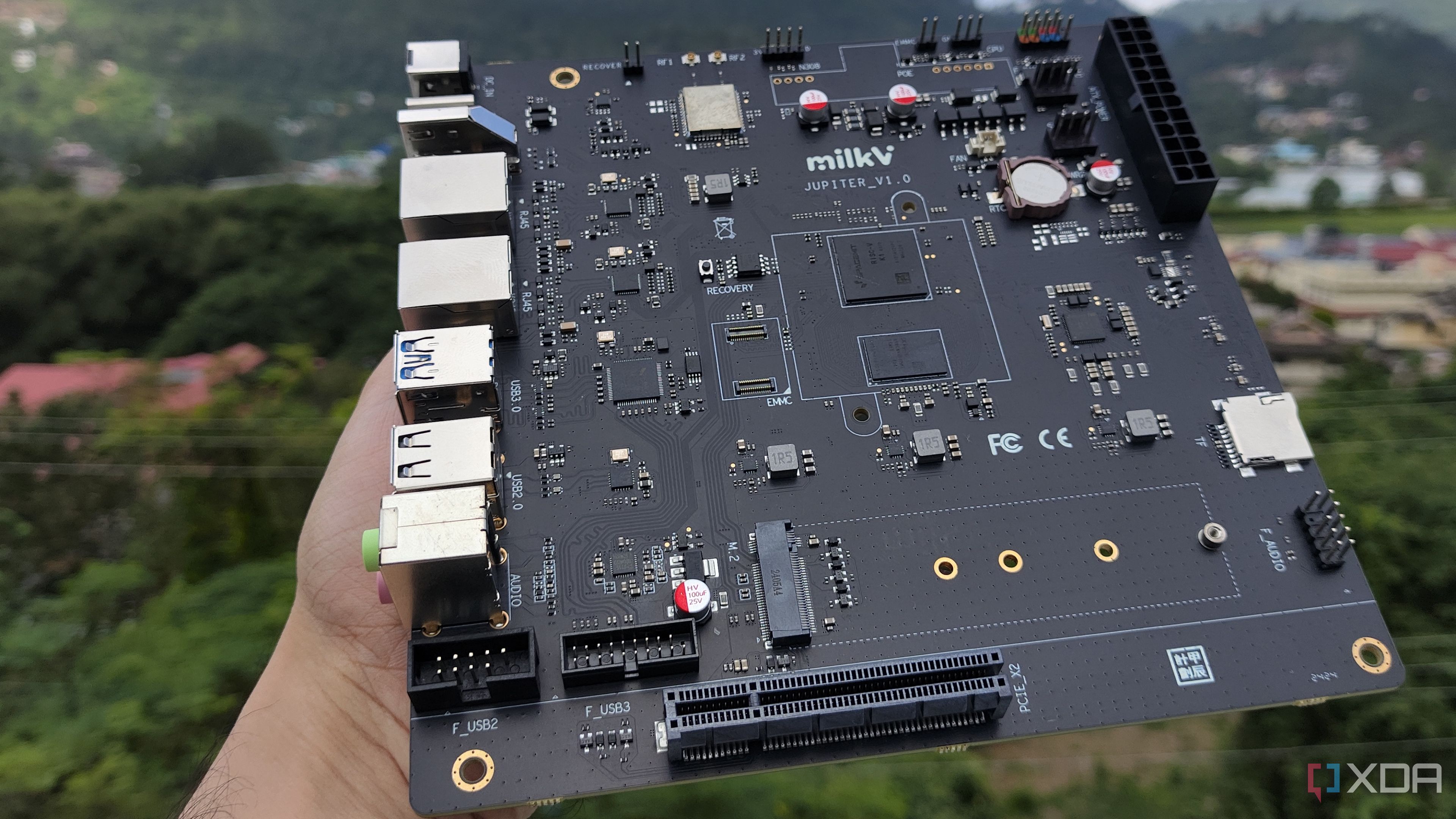 A personal holding the K1 version of the Milk-V Jupiter mini-ITX motherboard
