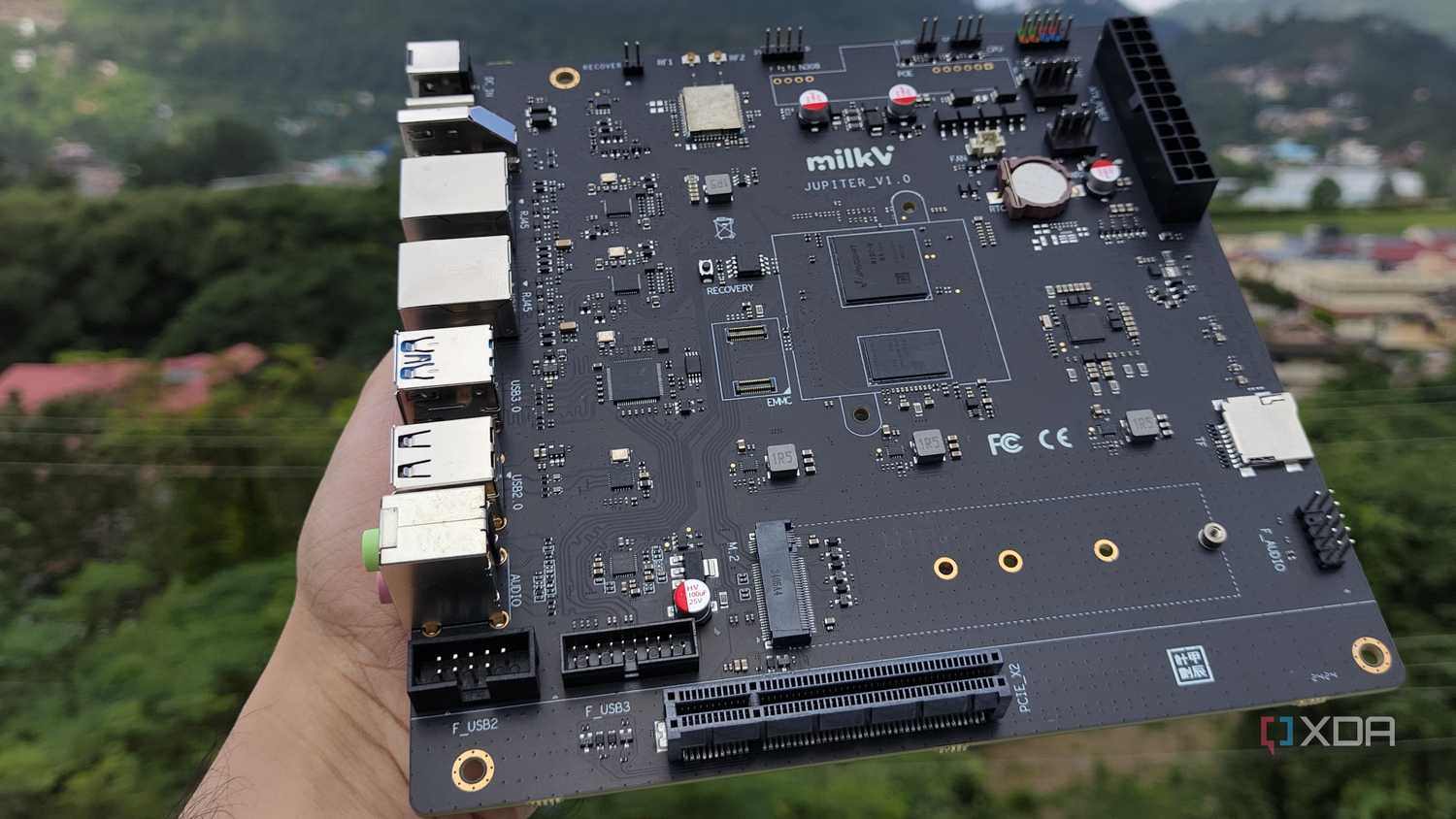 A personal holding the K1 version of the Milk-V Jupiter mini-ITX motherboard
