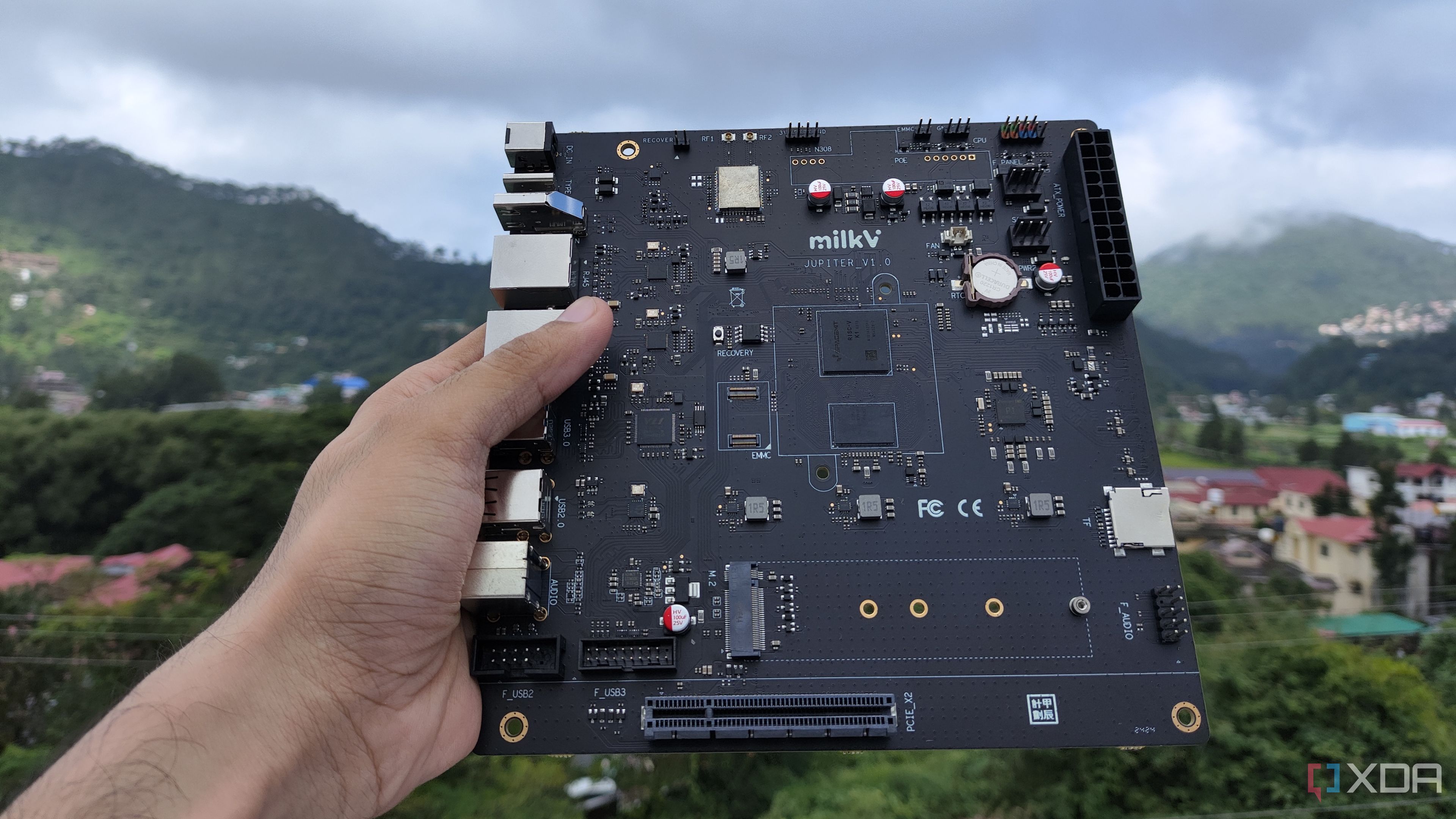 A personal holding the K1 version of the Milk-V Jupiter mini-ITX motherboard