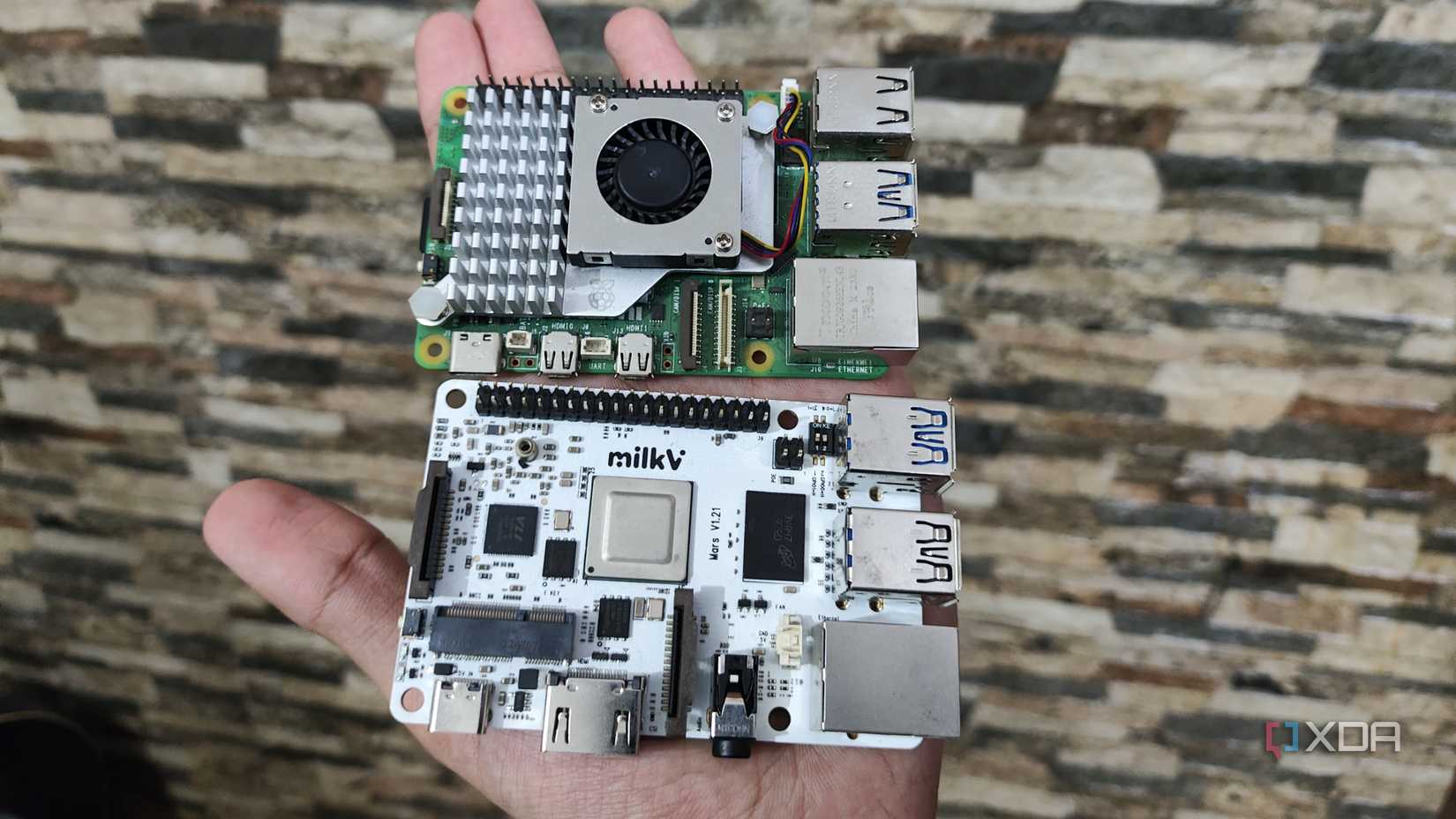 A person holding a Raspberry Pi 5 and a Milk-V Mars