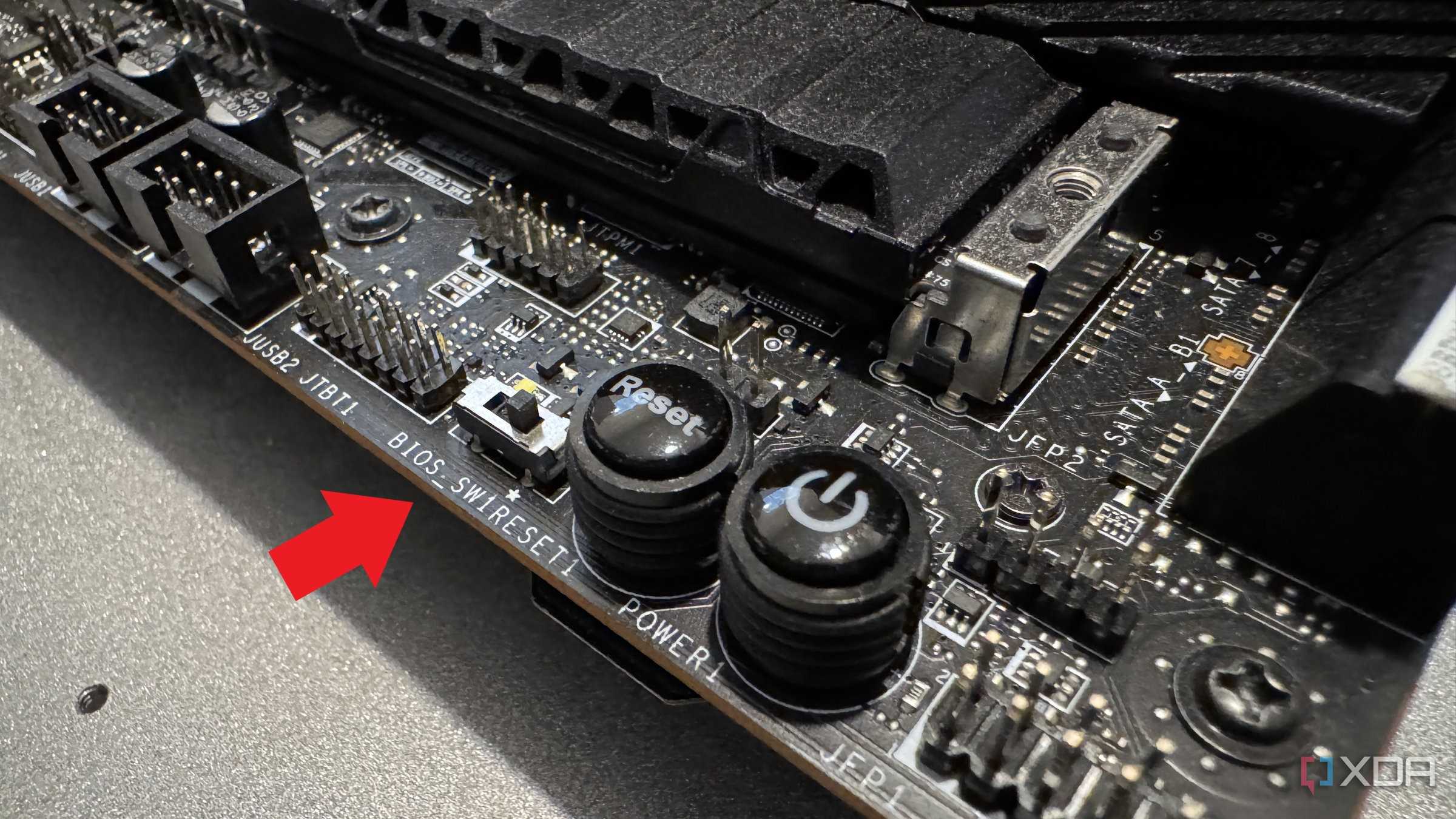 closeup of msi z690 unify-x motherboard with a red arrow pointing at the dual bios switch