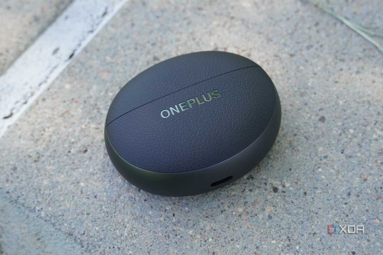 The OnePlus Buds Pro 3 case on a concrete bench.