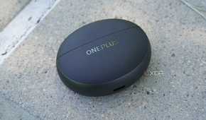 The OnePlus Buds Pro 3 case on a concrete bench.