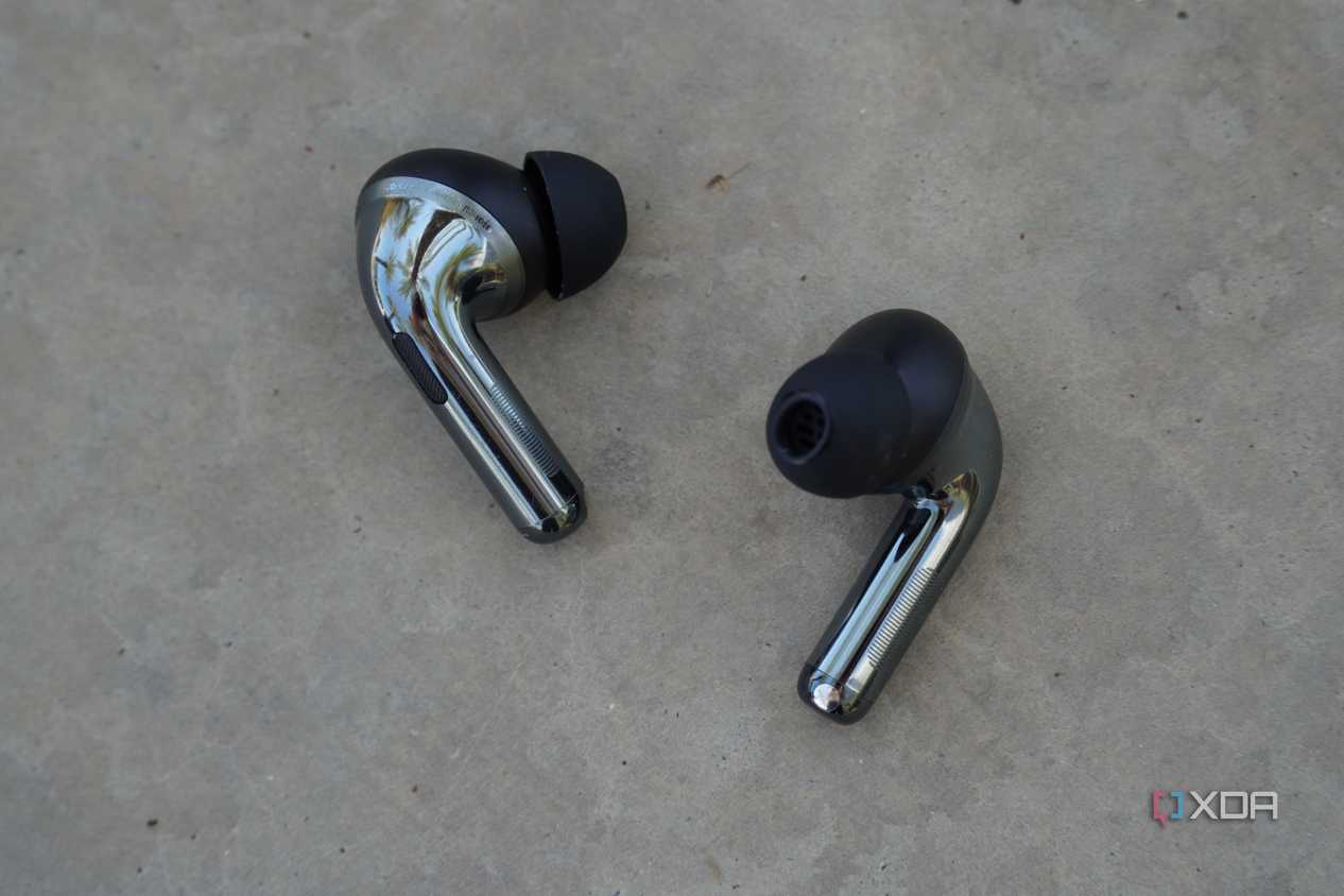 The OnePlus Buds Pro 3 earbuds on a concrete bench.
