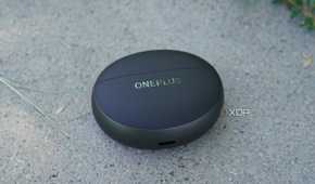 The OnePlus Buds Pro 3 case on a concrete bench.