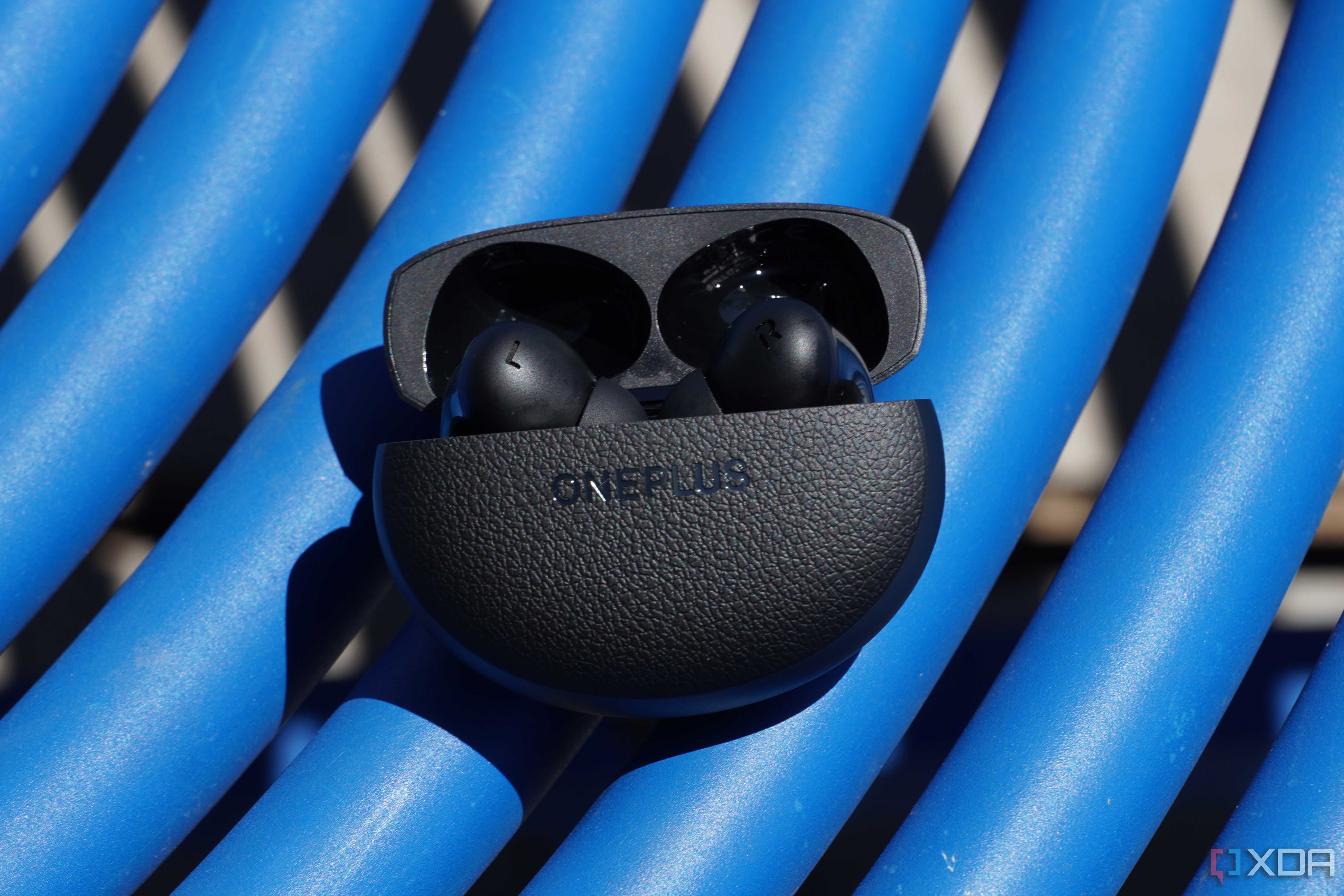 The OnePlus Buds Pro 3 on a blue table.