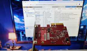An Ethernet card held in front of a monitor running Proxmox