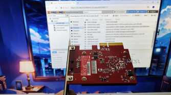 An Ethernet card held in front of a monitor running Proxmox