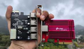 A person holding an NIC and a PCIe-to-USB card