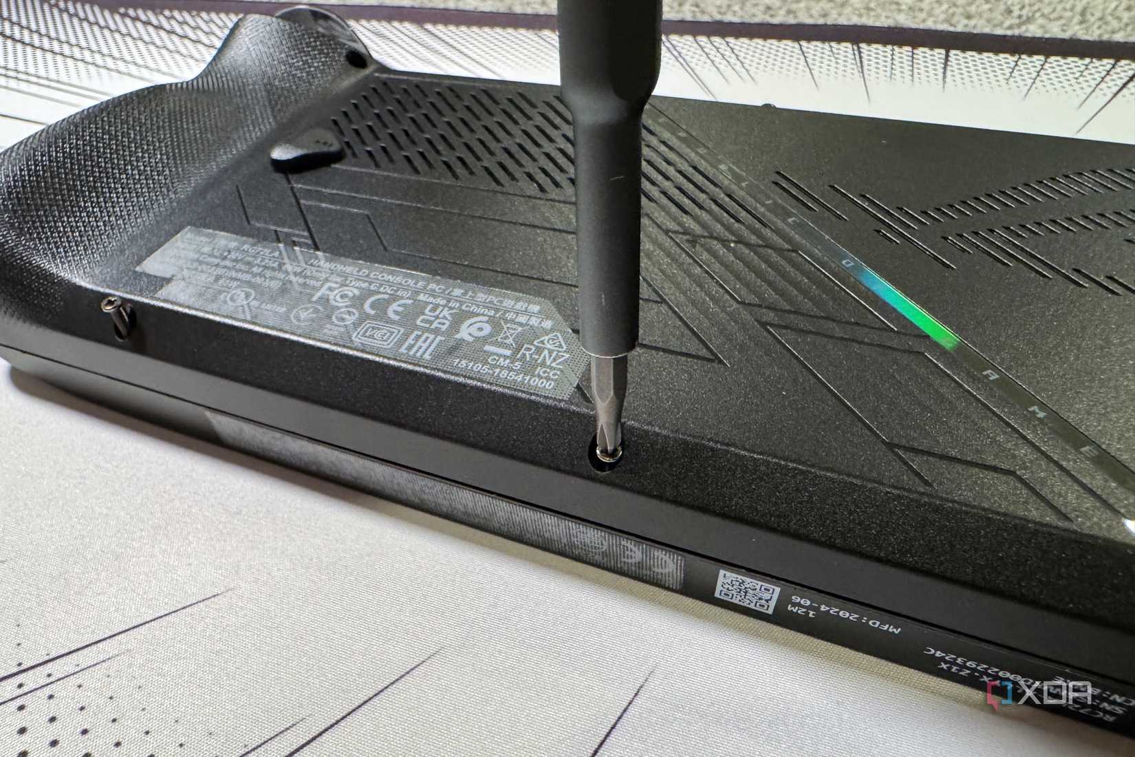 screwdriver refastening the rog ally x back panel