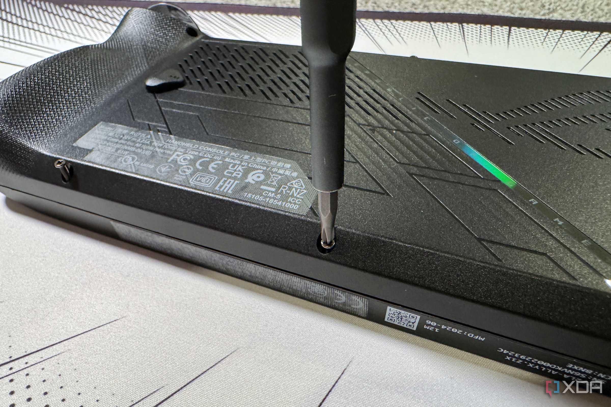 screwdriver refastening the rog ally x back panel