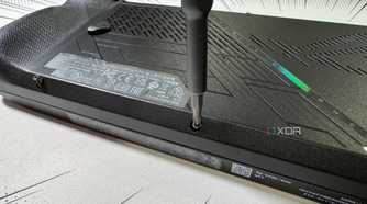 screwdriver refastening the rog ally x back panel