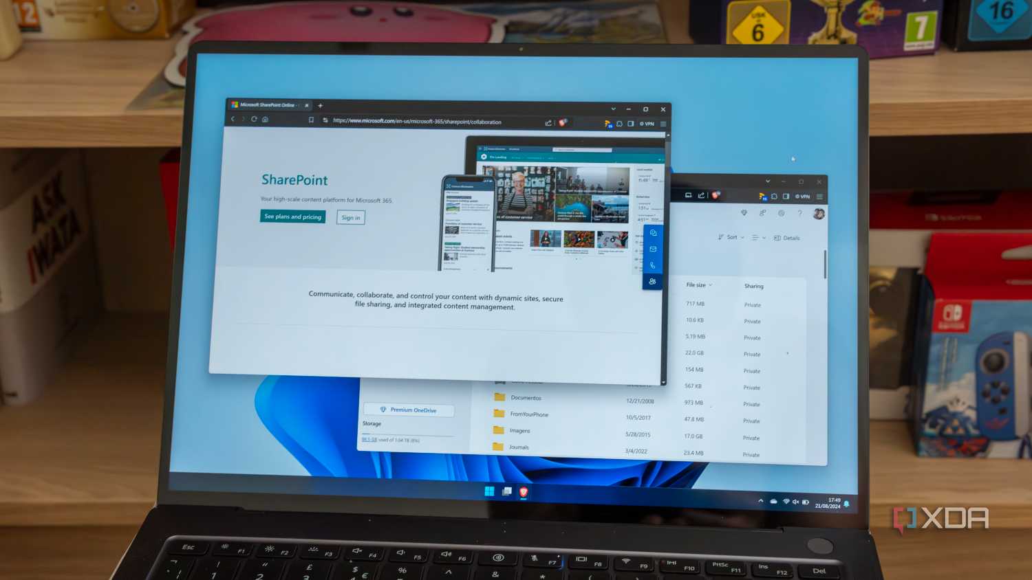 A Windows 11 laptop displaying the SharePoint product page and files in oneDrive