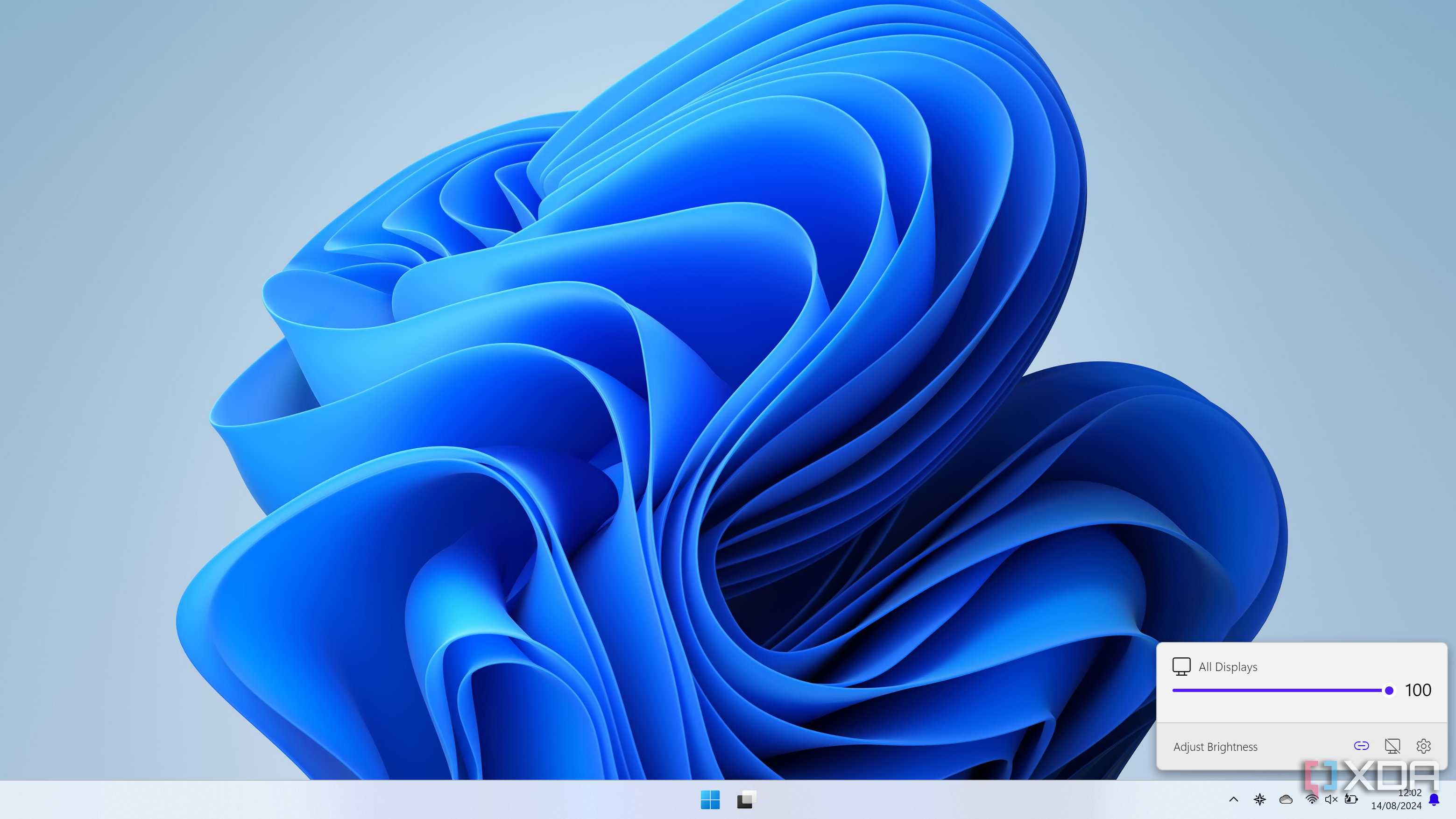 Screenshot of a Windows 11 desktop with a unified slider for all connected displays in the Twinkle Tray flyout
