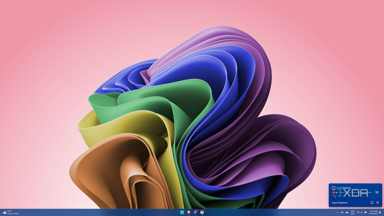 Screenshot of Windows 11 with a Twinkle Tray flyout showing a brightness slider for an external monitor
