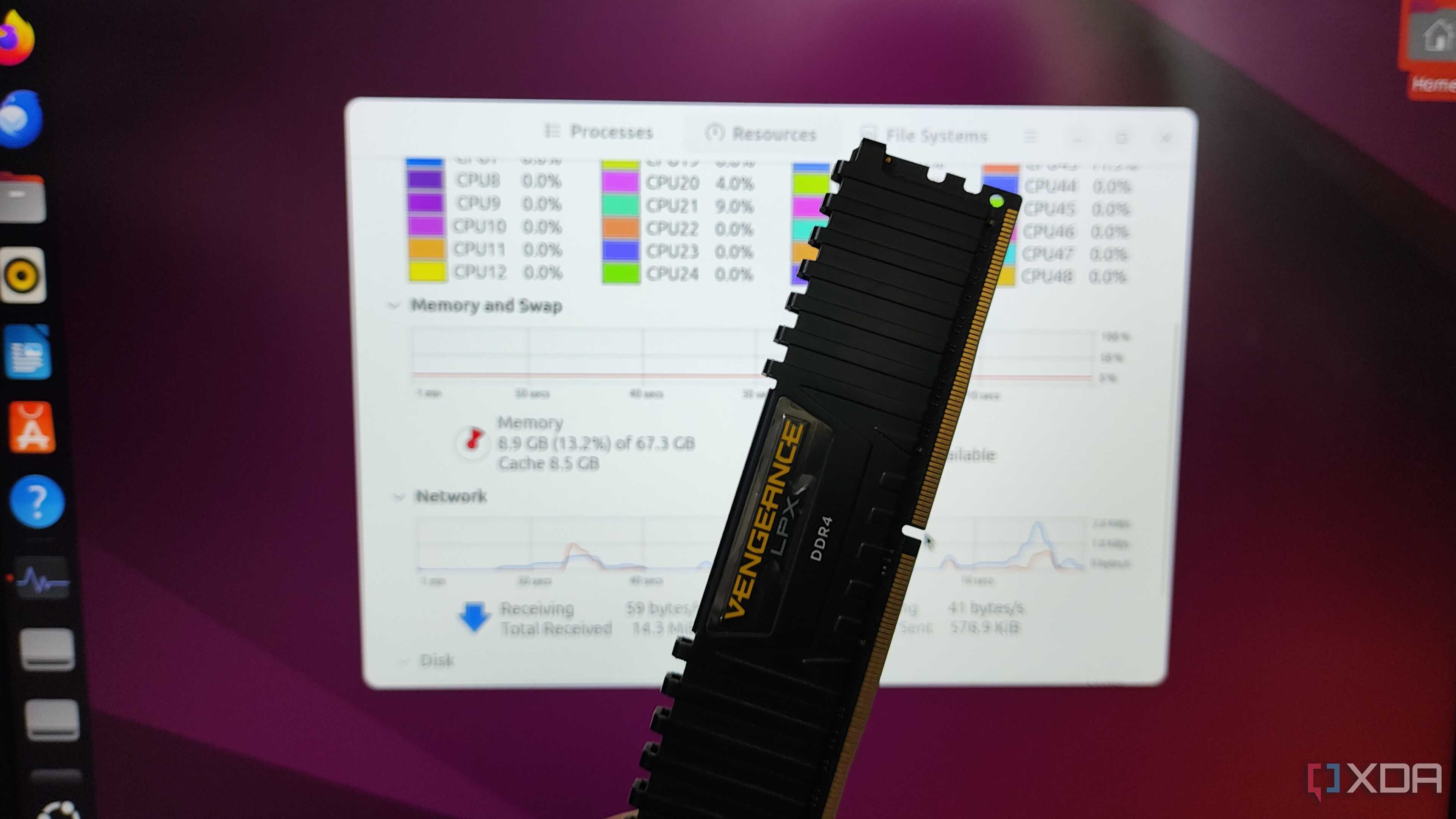 A person holding a USB stick in front of a monitor running Ubuntu from the RAM