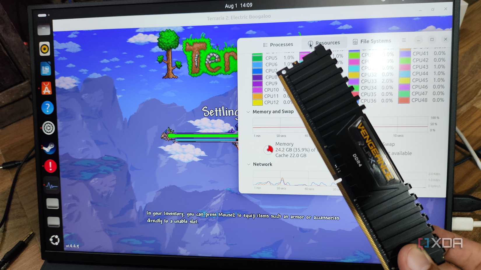 A person holding a RAM stick in front of a Uperfect UGame K118 monitor running Terraria