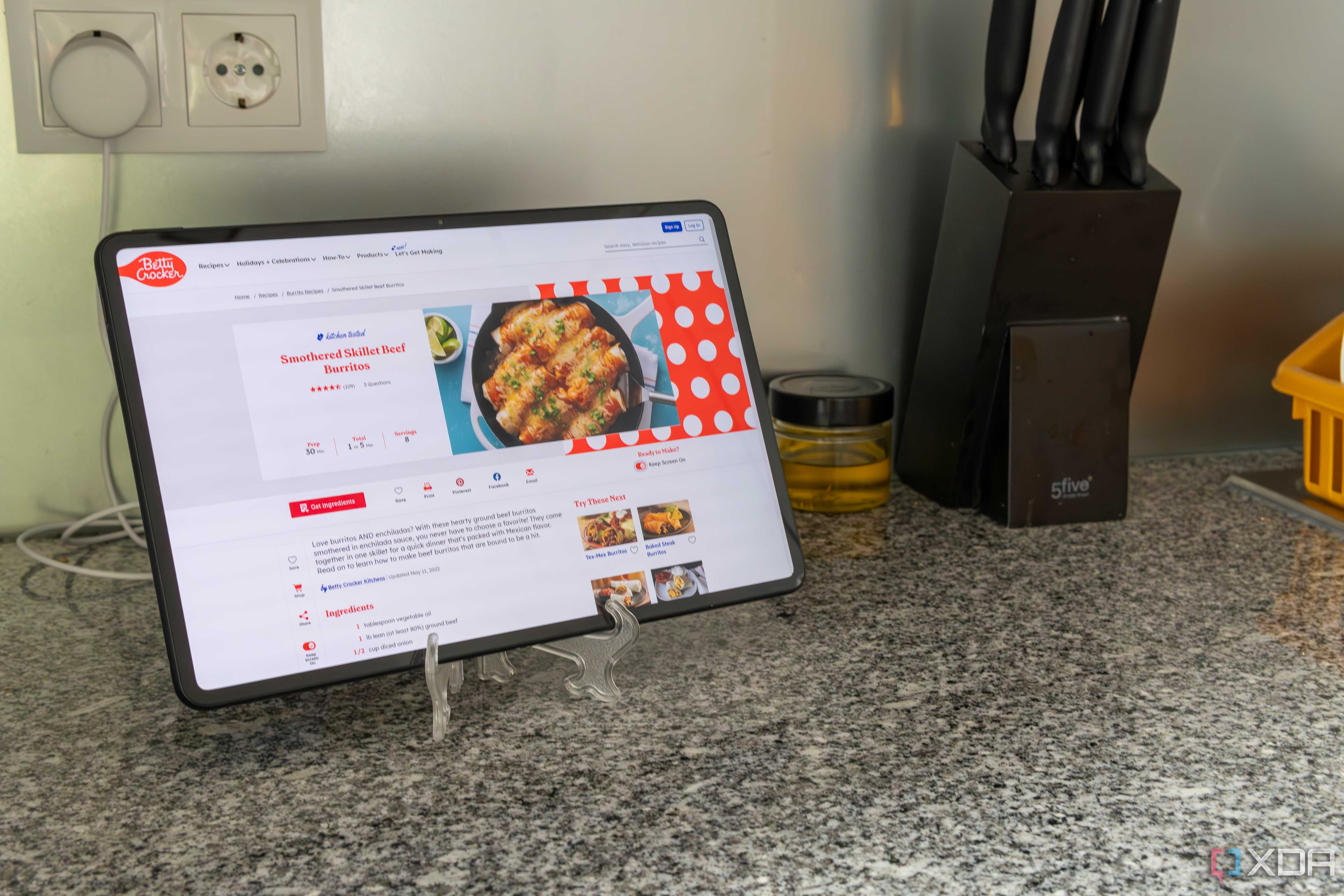 A tablet showing a recipe next to other kitchen kitchen tools