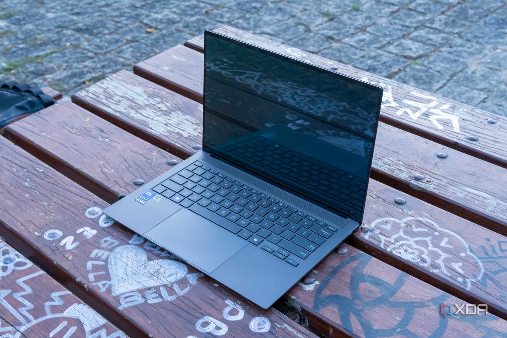 Angled view of the Asus Zenbook S 14 with the lid open at 90 degrees and the display turned off