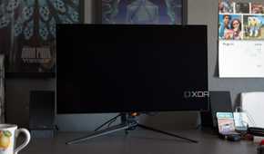 The ASUS ROG PG32UCDP showing a black screen on a desk.