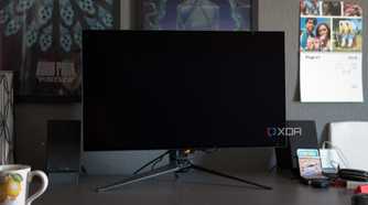 The ASUS ROG PG32UCDP showing a black screen on a desk.