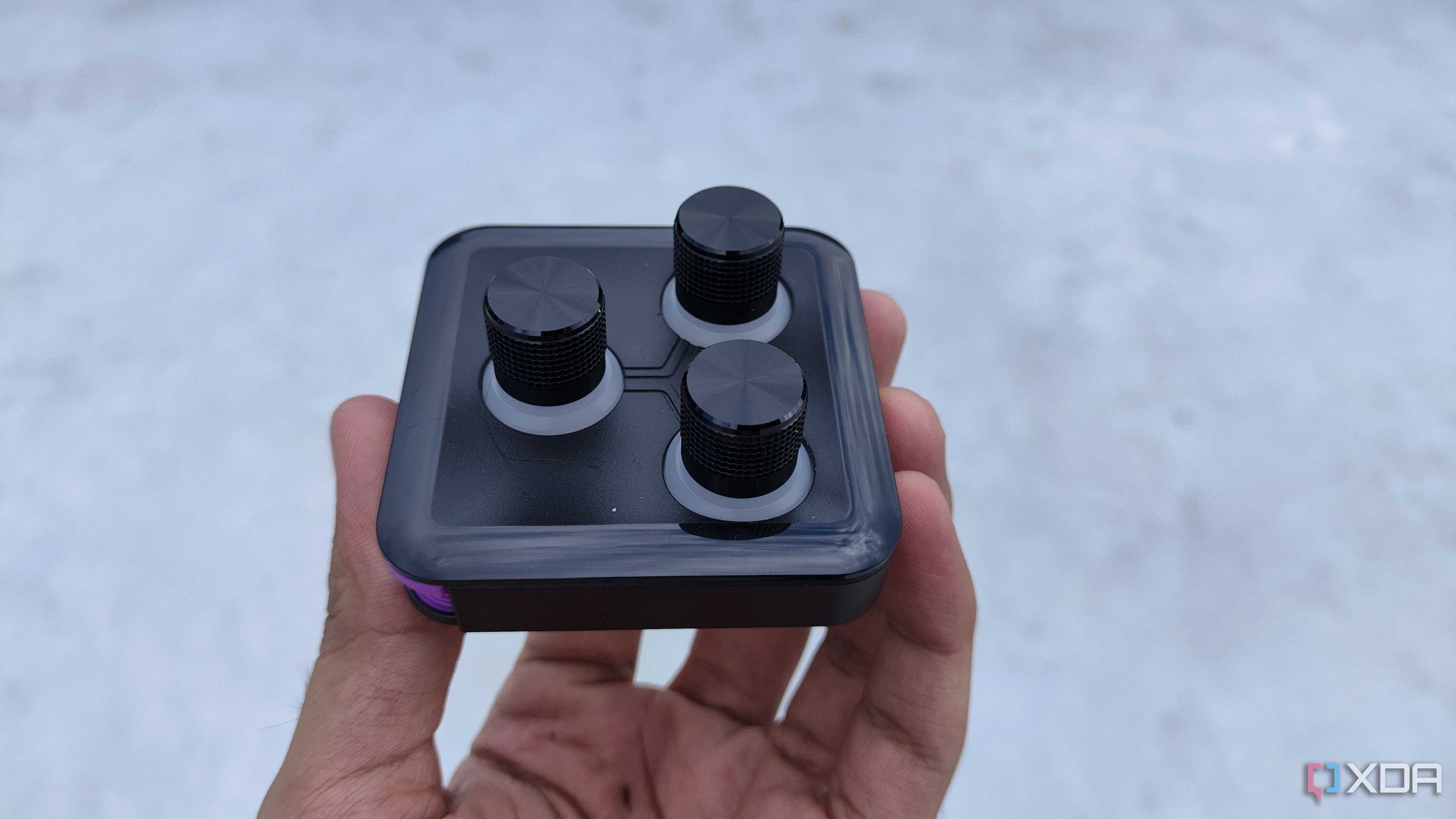 A person holding the 3-knob module of the Cooler Master MasterHUB