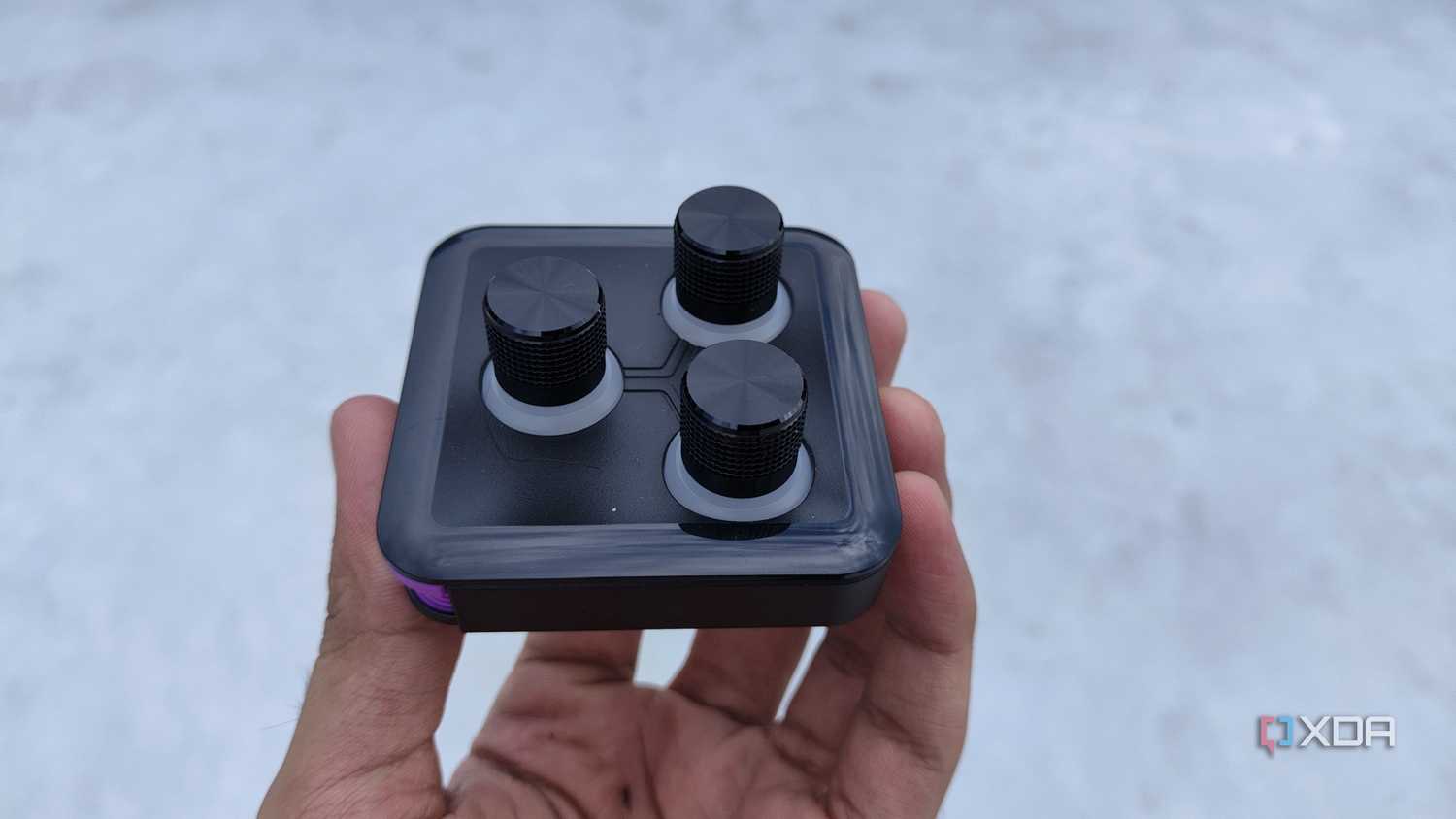 A person holding the 3-knob module of the Cooler Master MasterHUB