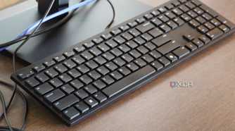 The Dell Wired Collaboration Keyboard on a monitor stand.