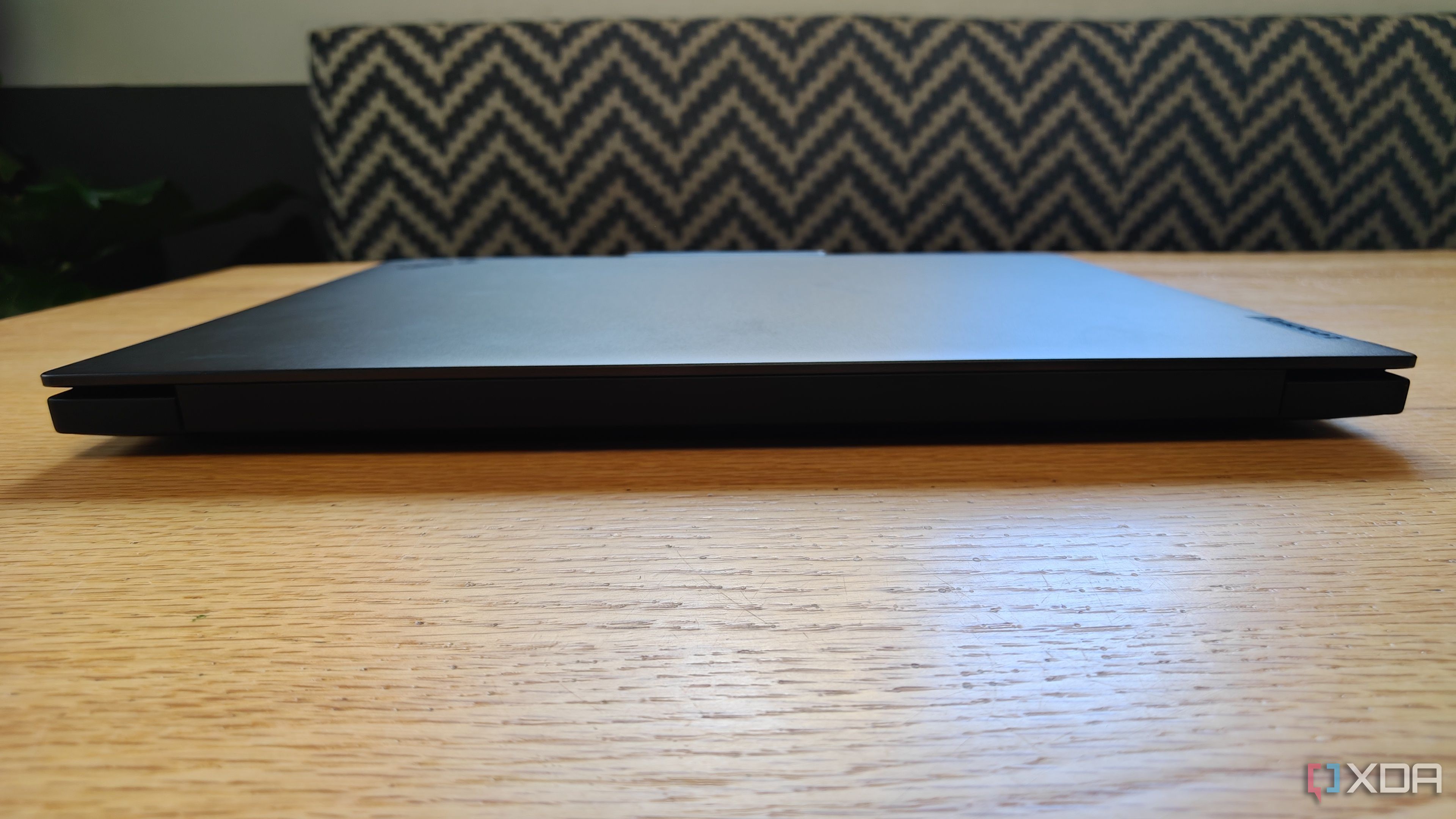 Front view of the ThinkPad P16 Gen 7 laptop on a table with a stiped couch in the background
