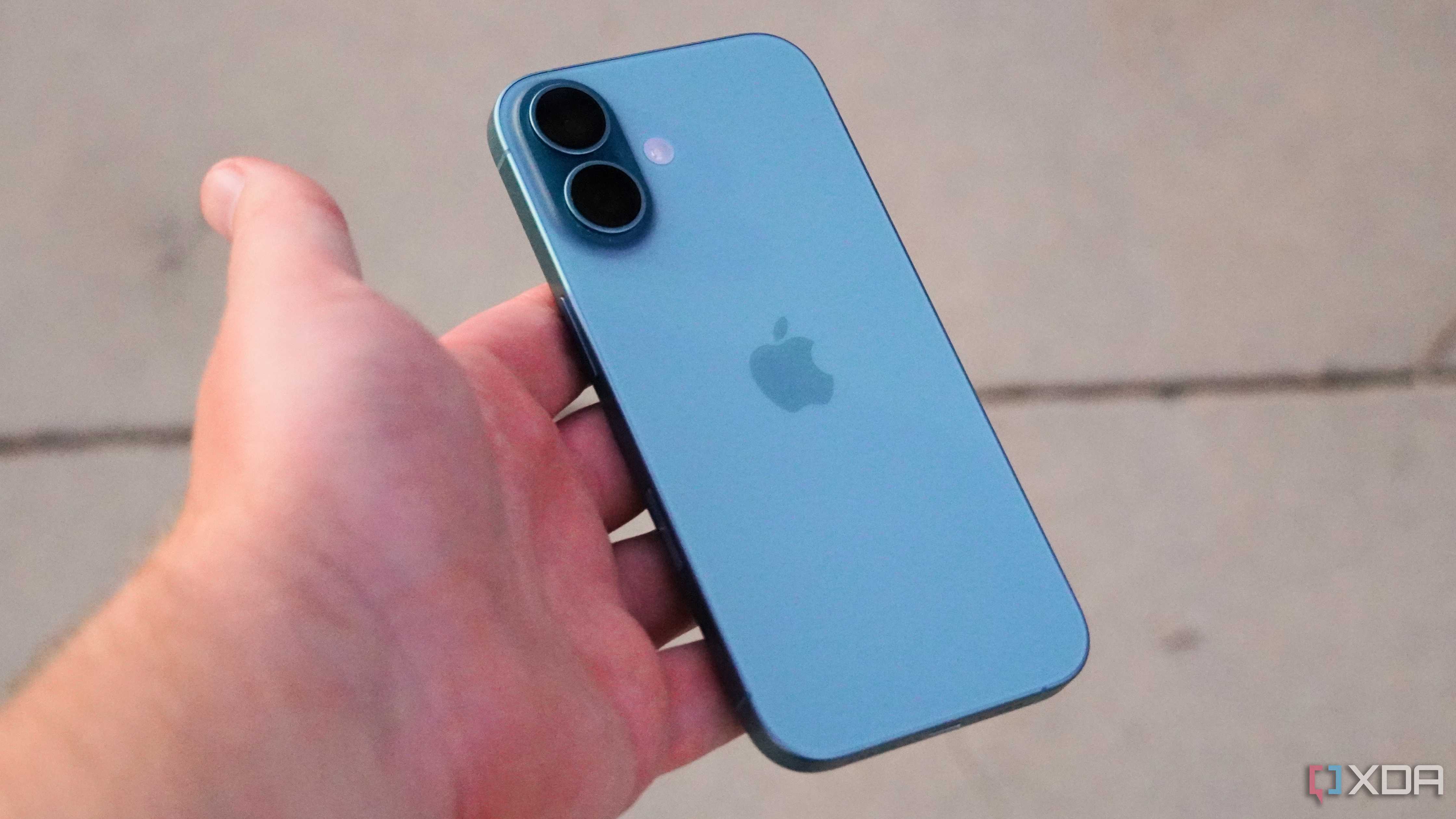 The iPhone 16 in the hand in Teal color.