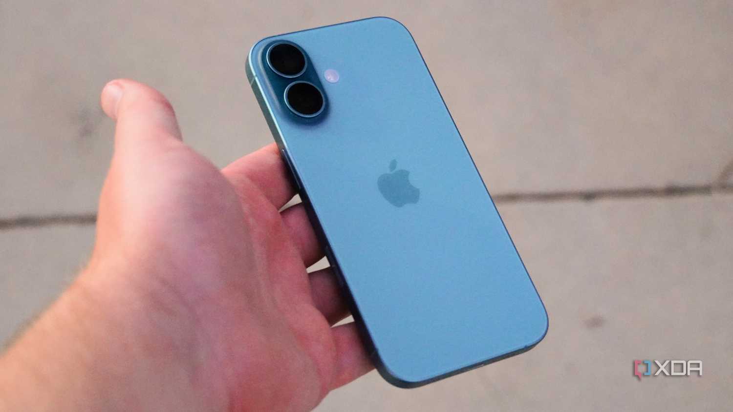 The iPhone 16 in the hand in Teal color.