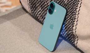 The iPhone 16 leaning against a pillow.