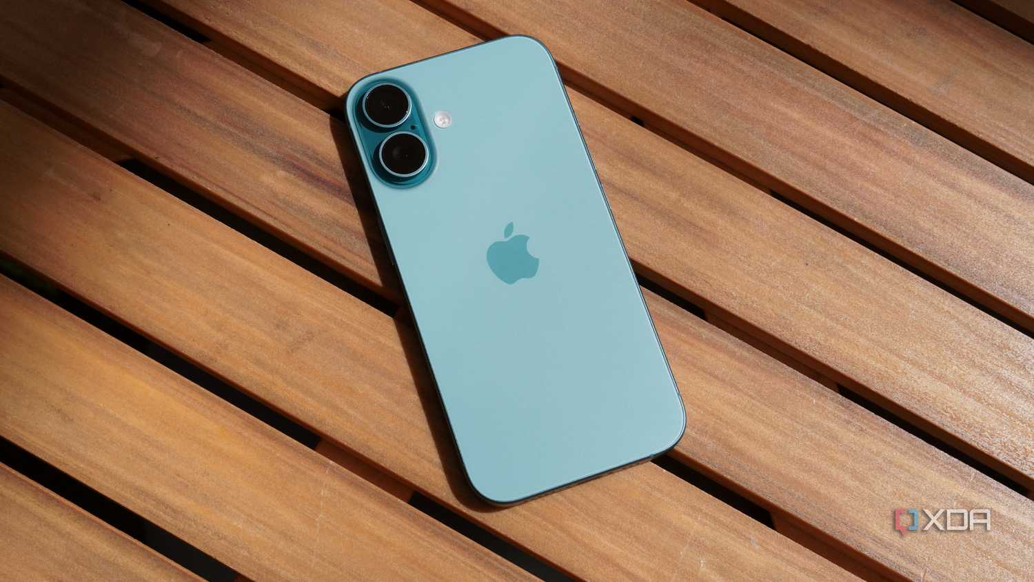 The iPhone 16 on a table outdoors.