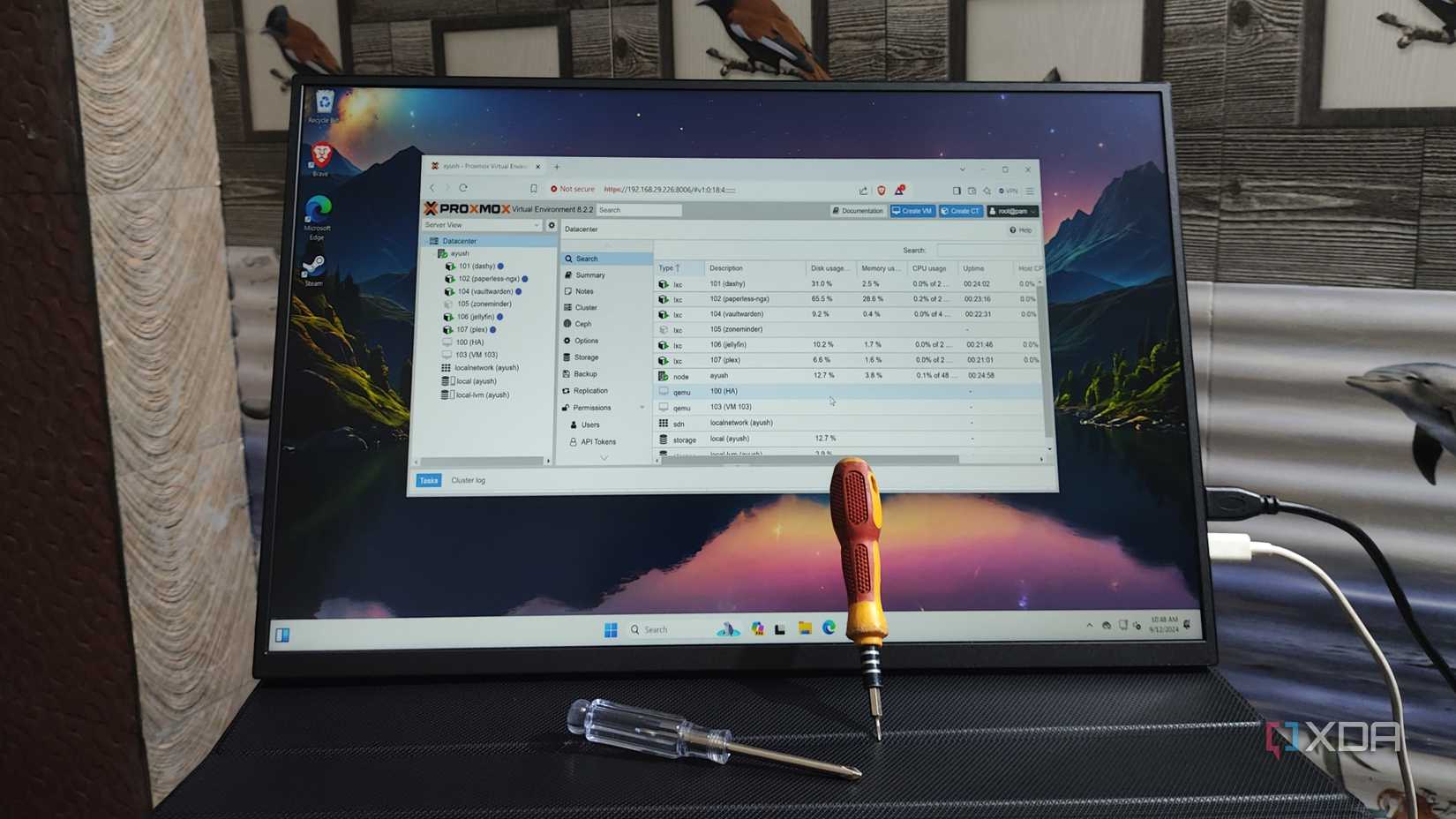 Proxmox UI runs on a portable monitor with two screwdrivers