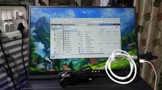 A monitor displaying the Proxmox UI, with two Ethernet cables lying in front of it