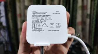 A person holding an official Raspberry Pi charger