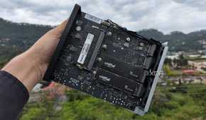 A person holding a TerraMaster F8 SSD Plus, with two PCIe 3 SSDs slotted into the NAS