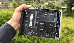 A person holding a TerraMaster F8 SSD Plus, with two PCIe 3 SSDs slotted into the NAS