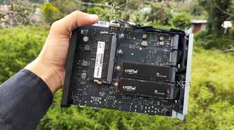 A person holding a TerraMaster F8 SSD Plus, with two PCIe 3 SSDs slotted into the NAS