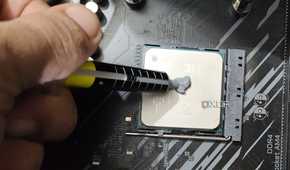 An image of a person applying thermal paste on a Ryzen 5 5600X.