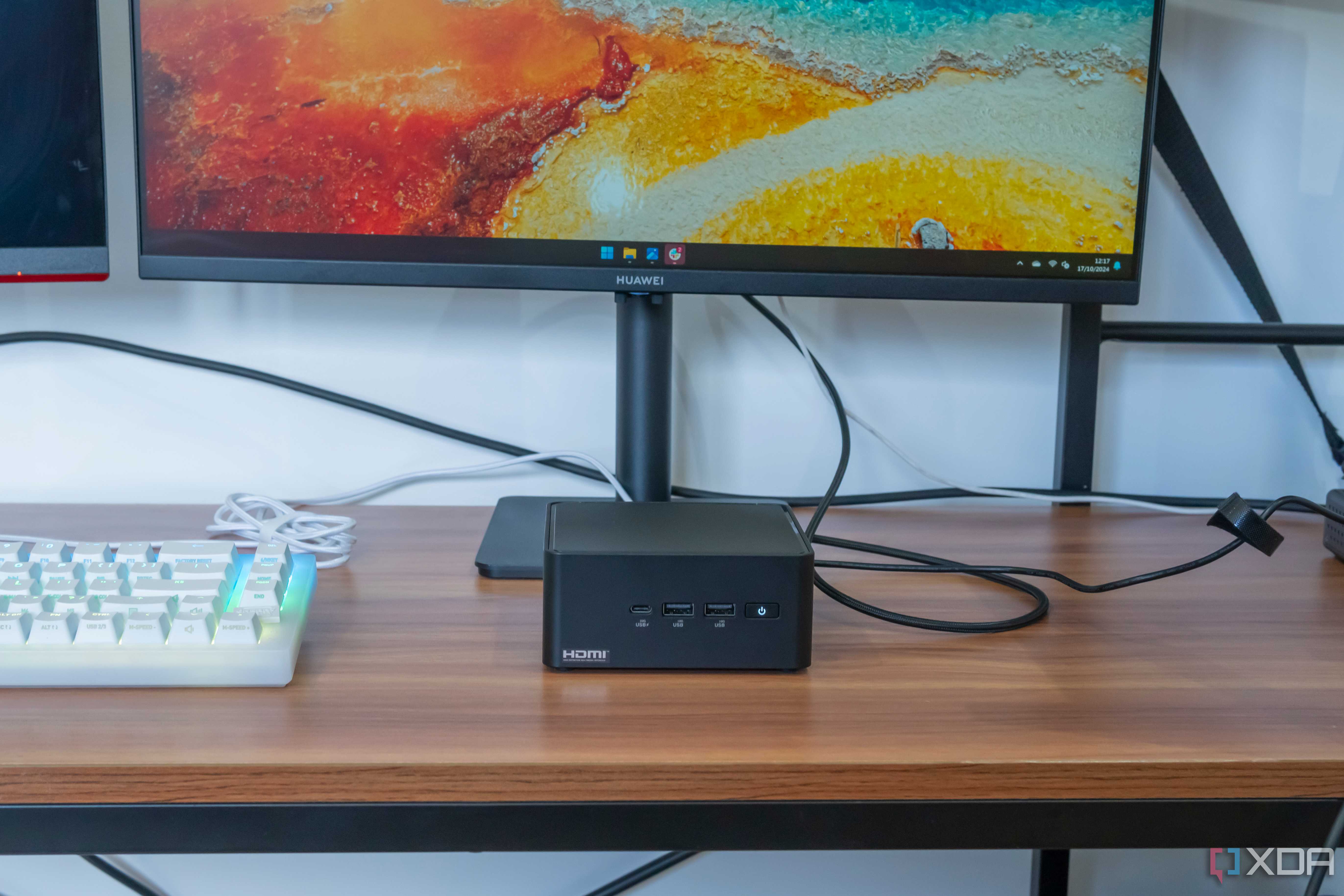 Front view of the Asus NUC 14 Pro in front a monitor and next to a keyboard