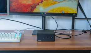 Front view of the Asus NUC 14 Pro in front a monitor and next to a keyboard