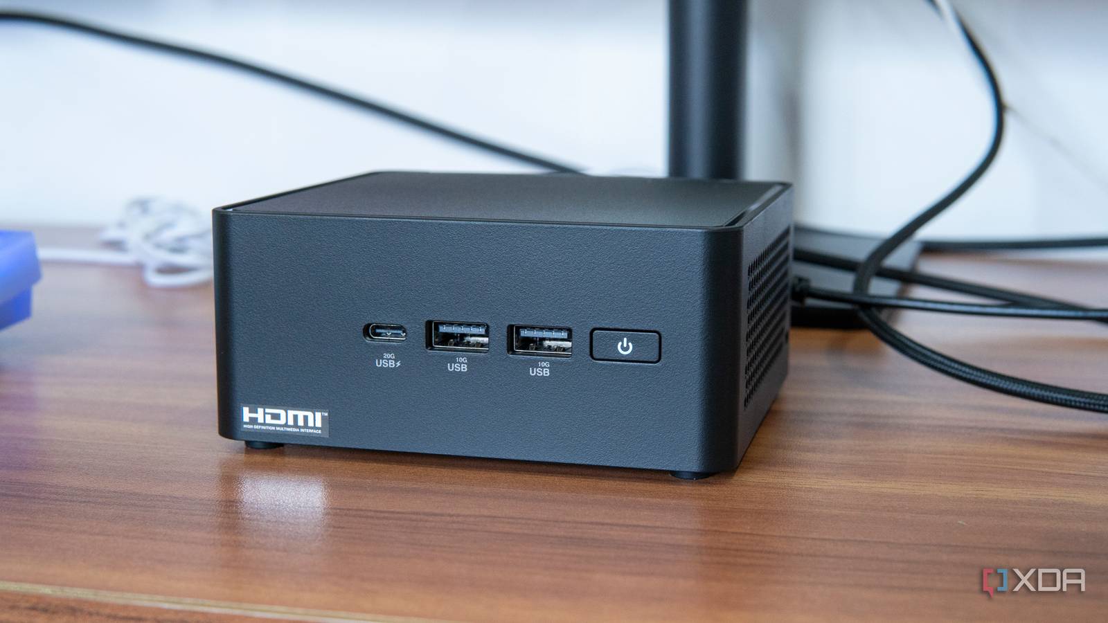 Angled front view of the Asus NUC 14 Pro in front of a monitor stand
