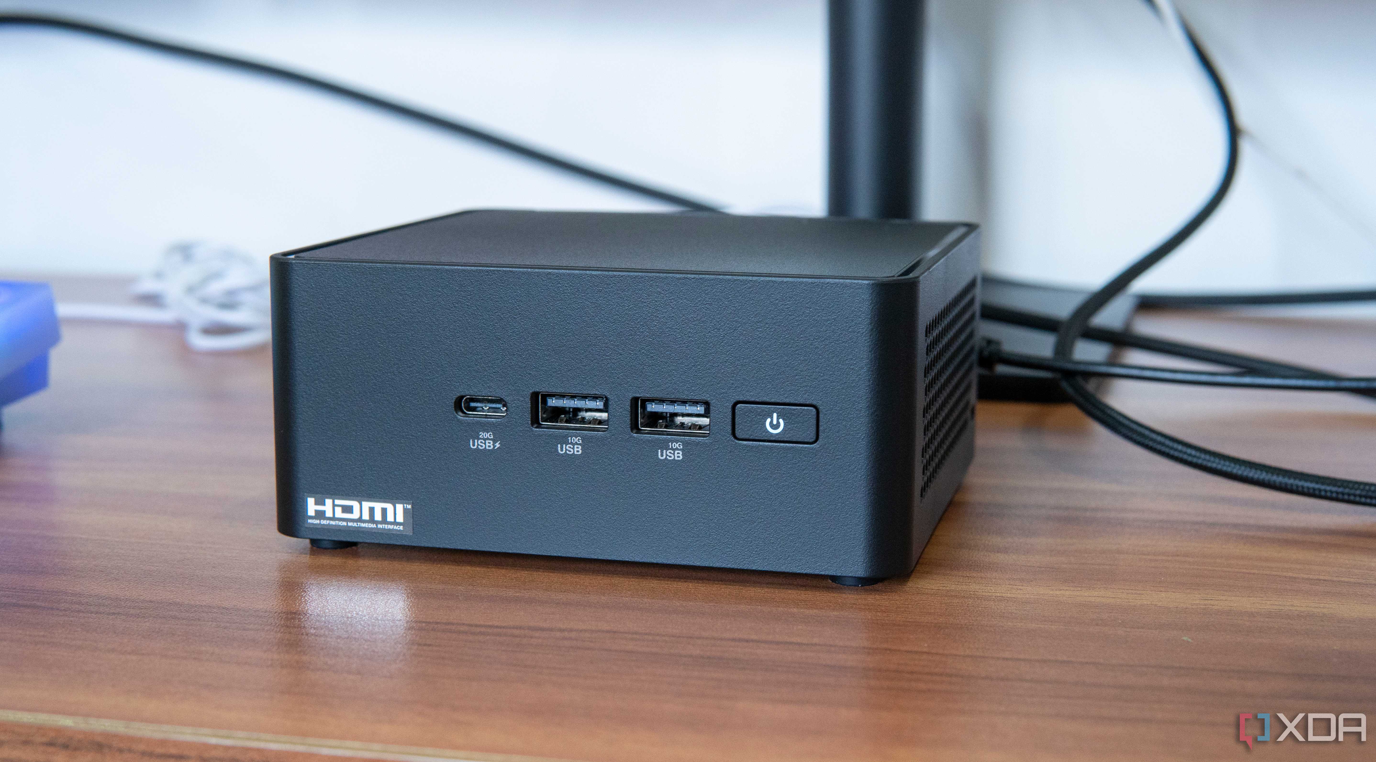 Angled front view of the Asus NUC 14 Pro in front of a monitor stand