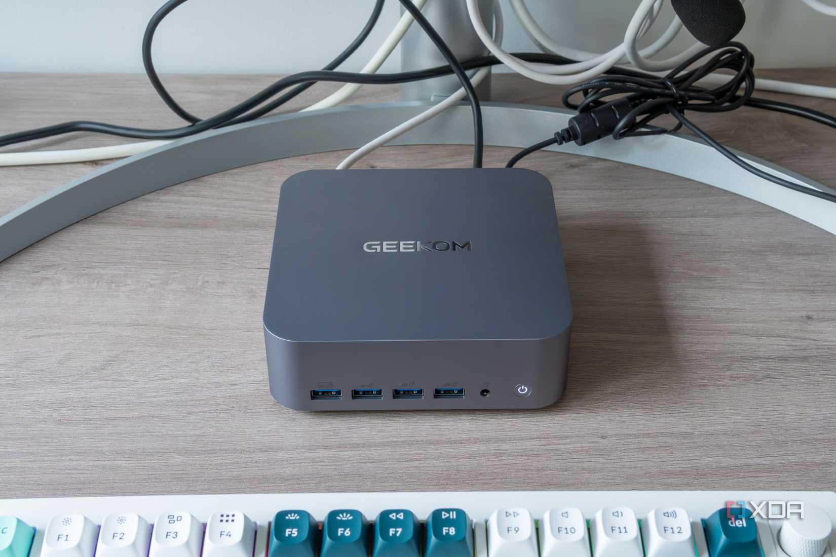 Front view of the Geekom GT1 Mega in front of a monitor and with a keyboard in front of it