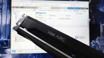 An Intel Arc GPU hovering in front of a monitor